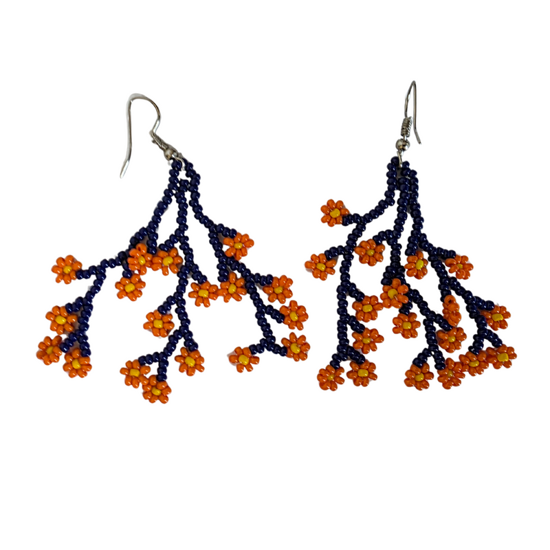 A pair of beaded dangle earrings featuring dark navy blue branches with small orange and yellow flower clusters, suspended from silver fishhook wires on a plain white background.