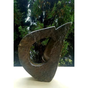 A brown, abstract-shaped stone sculpture of a face.