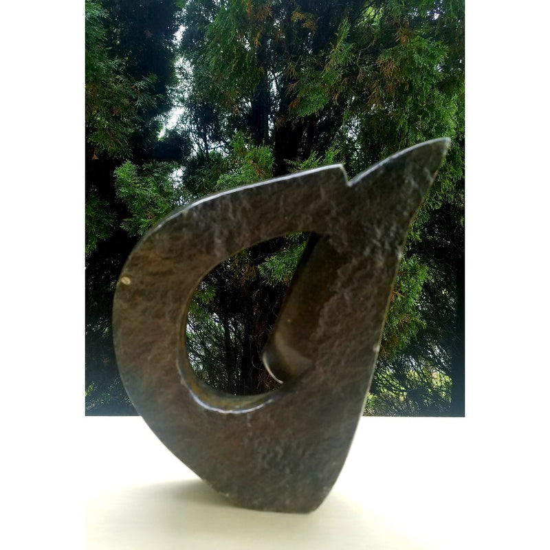 A brown, abstract-shaped stone sculpture of a face.