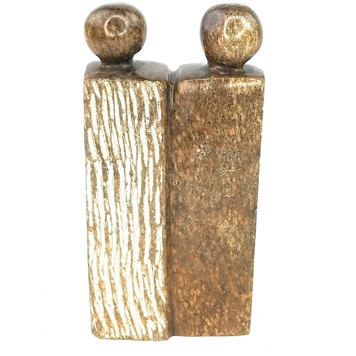 A hand-carved stone sculpture of a couple, with a textured surface and a polished finish.
