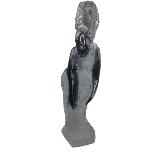 A black stone sculpture of a lady's figure, hand-carved in Zimbabwe.