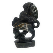 A hand-carved stone statue of an elephant mother and child, primarily in darker tones, representing the Shona sculpture style from Zimbabwe.