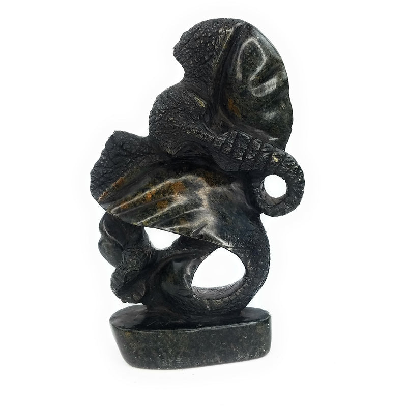 A hand-carved stone statue of an elephant mother and child, primarily in darker tones, representing the Shona sculpture style from Zimbabwe.