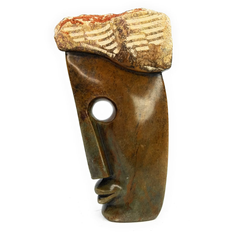A Shona stone sculpture of an abstract face with a hole for the eye, hand-carved in Zimbabwe.