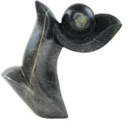 A black, abstract-style Shona sculpture made of stone, depicting an artistic representation that may vary slightly in color, size, and motif due to its handmade nature.