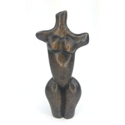 A handcrafted stone sculpture of a female torso, with exaggerated hips and breasts, representing the fertility of Mother Earth.