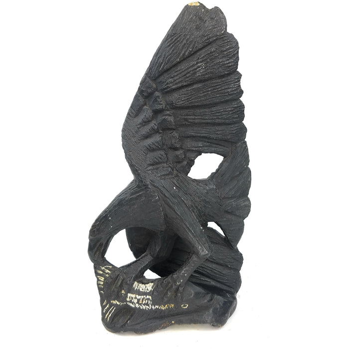 A black serpentine sculpture of an African fish eagle perched on a tree with a catch, handcrafted by Shona artisans in Zimbabwe.