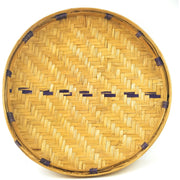 A traditional African winnowing basket, with a beige color and a natural weave pattern, indicative of handcrafted quality and cultural heritage.