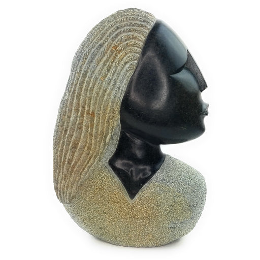 A hand-carved stone sculpture of a woman's head and torso with a serene expression, primarily in black and white tones.