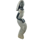 A hand-carved stone sculpture of a woman, with a combination of gray and black colors, showcasing traditional African art.