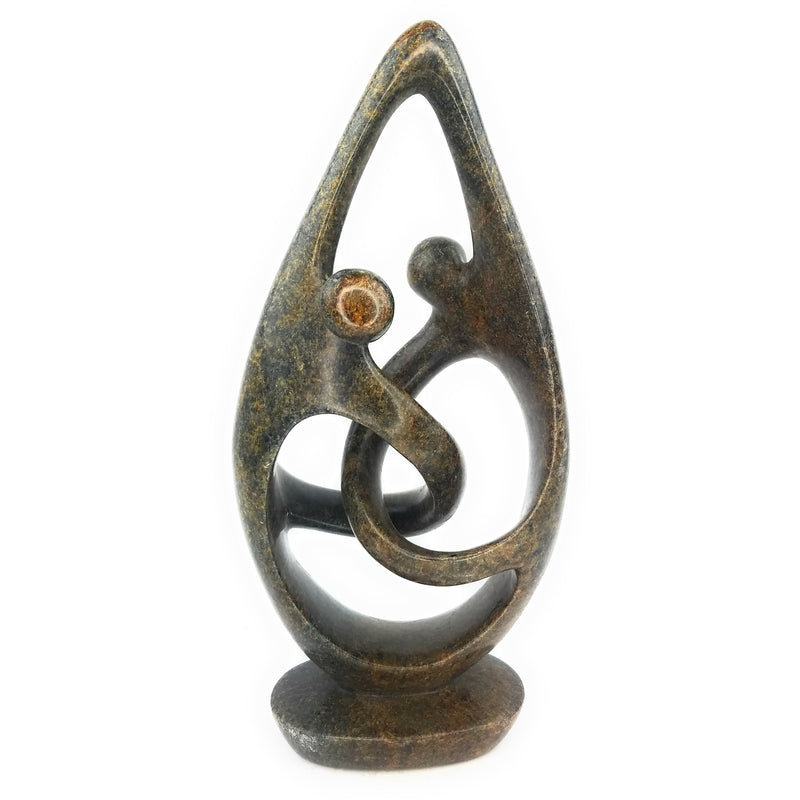 A hand-carved stone figurine of a dancing couple, with intricate detailing and a textured background.