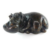 A hand-carved serpentine stone sculpture of a hippo, resting in a curved position.