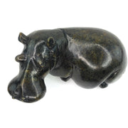 A hand-carved stone sculpture of a hippo, with a textured dark finish.