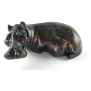 A hand-carved serpentine stone sculpture of a hippo, with a textured and rugged finish.