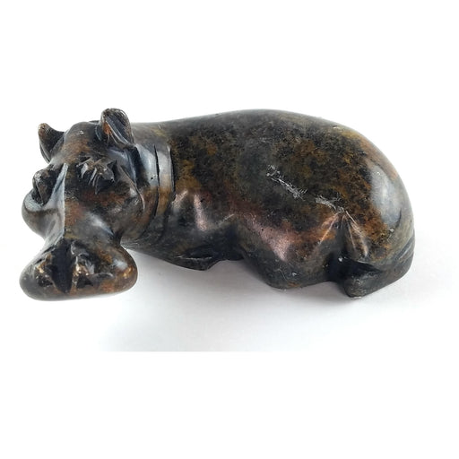 A hand-carved serpentine stone sculpture of a hippo, with a textured and rugged finish.