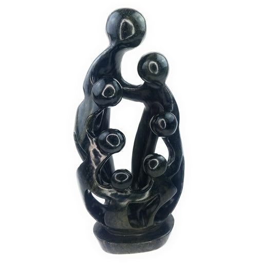 A hand-carved serpentine stone sculpture depicting a family of seven figures in a protective embrace, with intricate detailing and a dark-colored finish.