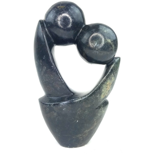 A black soapstone sculpture of a kissing couple, hand-carved in Zimbabwe.