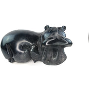 A hand-carved serpentine stone sculpture of a hippo in a dynamic pose, showcasing the animal's body and head.