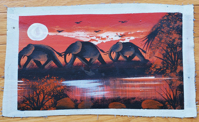 A canvas painting featuring a group of elephants walking in a line with a red and black sunset background, trees, and vegetation.