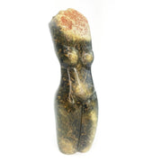 A handcrafted stone sculpture of a female torso with exaggerated hips and breasts, representing the fertility of Mother Earth.