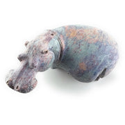A hand-carved stone sculpture of a hippo, with a serrated edge indicating the sculpture was created from a single piece of stone.