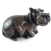 A hand-carved stone sculpture of a hippo, with a dark serpentine finish.