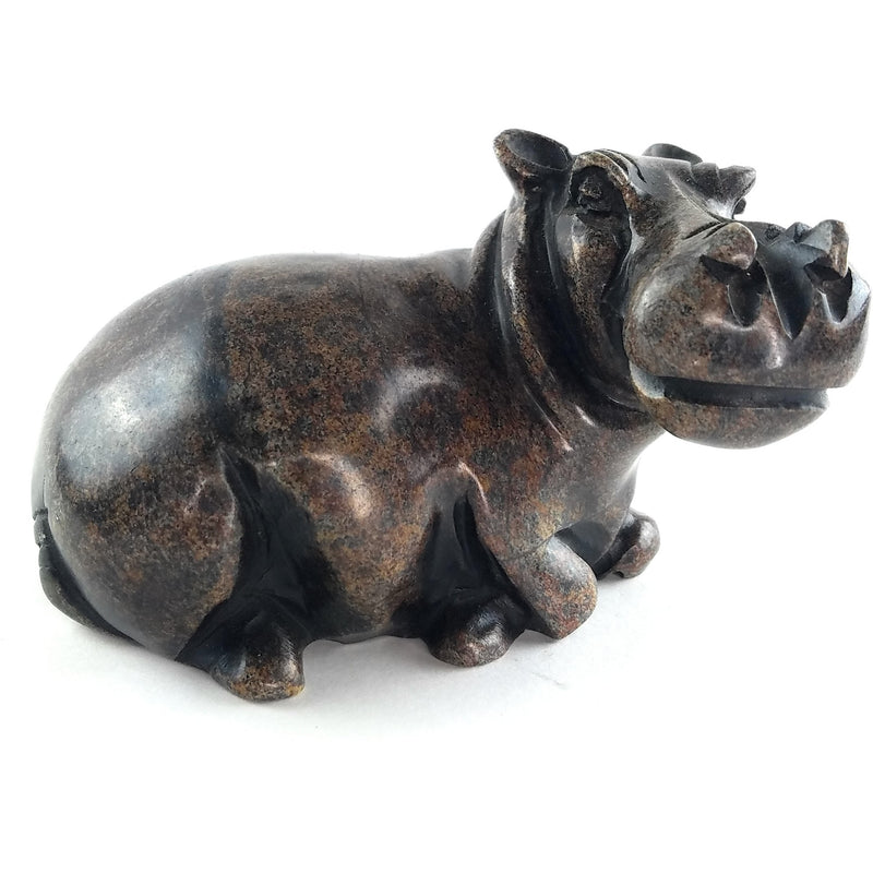A hand-carved stone sculpture of a hippo, with a dark serpentine finish.