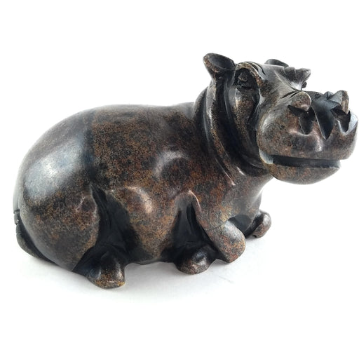 A hand-carved stone sculpture of a hippo, with a dark serpentine finish.