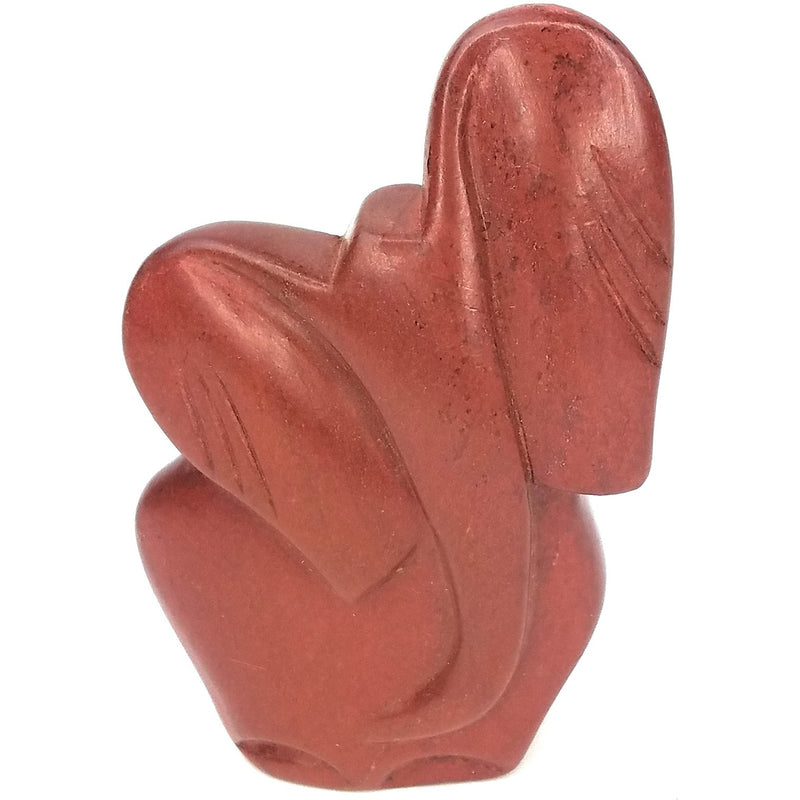 A hand-carved red stone elephant statue, with a joyful trumpet pose, indicating positive symbolism.