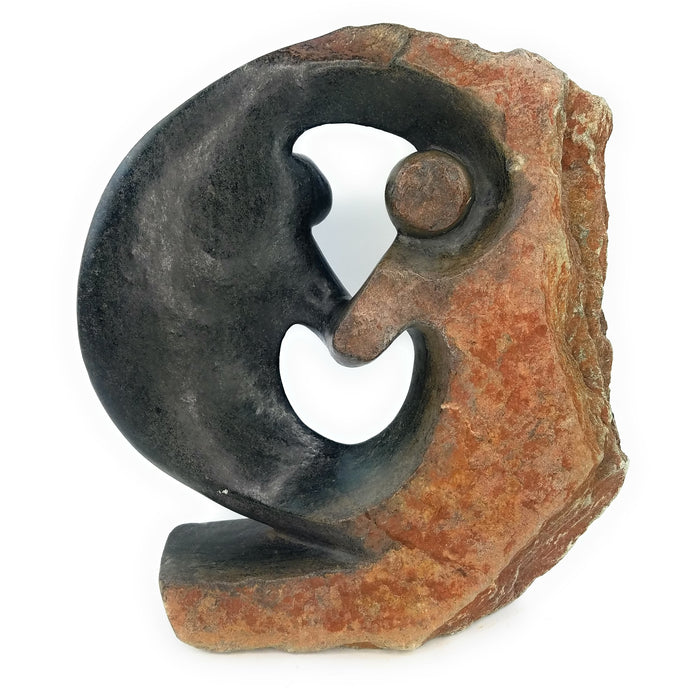 A hand-carved stone sculpture depicting an eternal embrace, representing the profound and everlasting love between two people, in a rustic, natural finish.