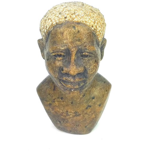 A brown Shona stone female bust, handcrafted in Zimbabwe, with a realistic face and a textured hair top.