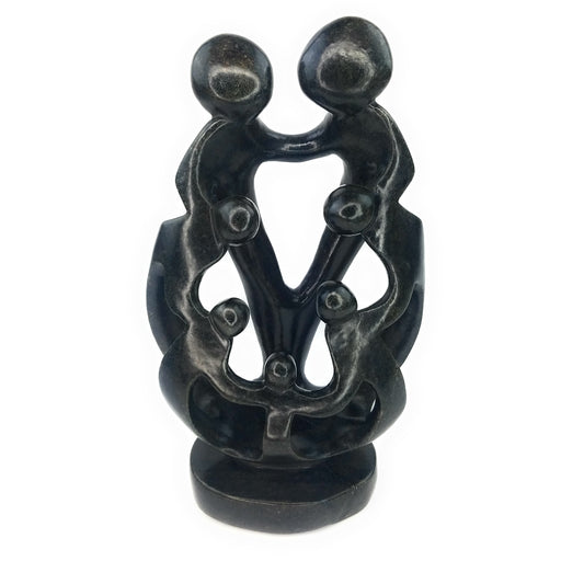 A hand-carved stone sculpture depicting a family of seven, with a mother, father, and five children, in black.