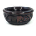 A hand-carved ebony wood bowl with animal patterns, primarily dark in color and smoothly polished on the inside.