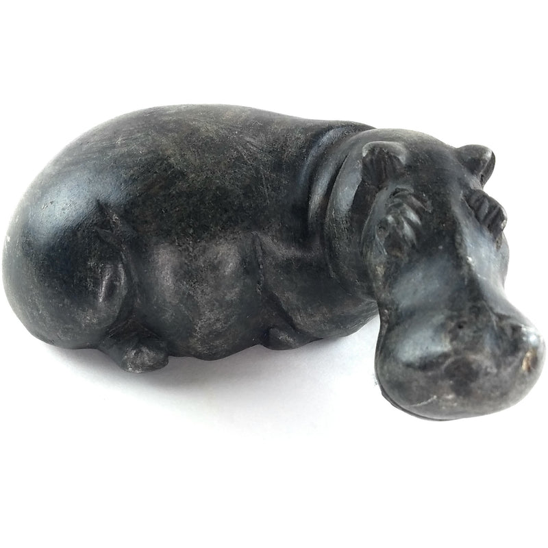 A hand-carved stone sculpture of a hippo, with a dark serpentine finish.
