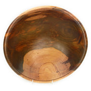A hand-carved Teak wood decorative bowl with a natural grain finish, displayed on a stand.