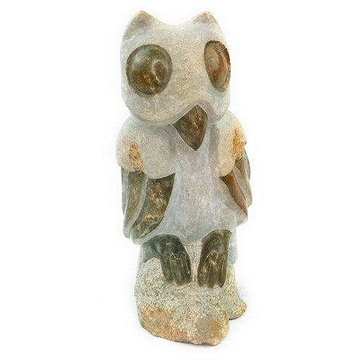 A hand-carved stone owl sculpture, primarily in shades of grey and beige, with a textured surface indicating its handcrafted nature.