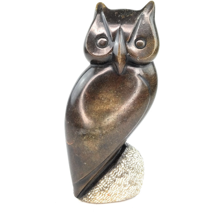 A hand-carved stone sculpture of an owl with a textured surface and a natural color palette.